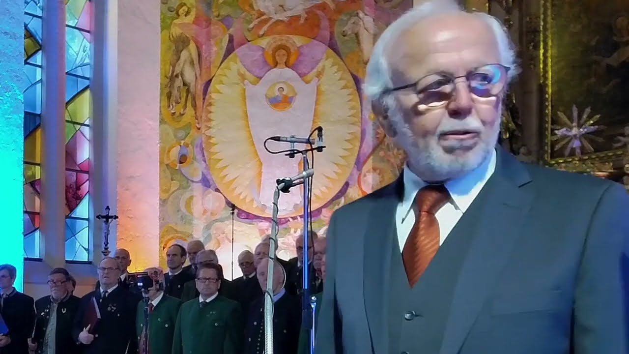 Chor singt vor einem goldenen Altar in einer Kirche
