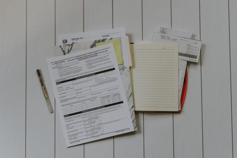 Stapel Papierunterlagen auf einem Tisch, Sinnbild für Förderanträge
